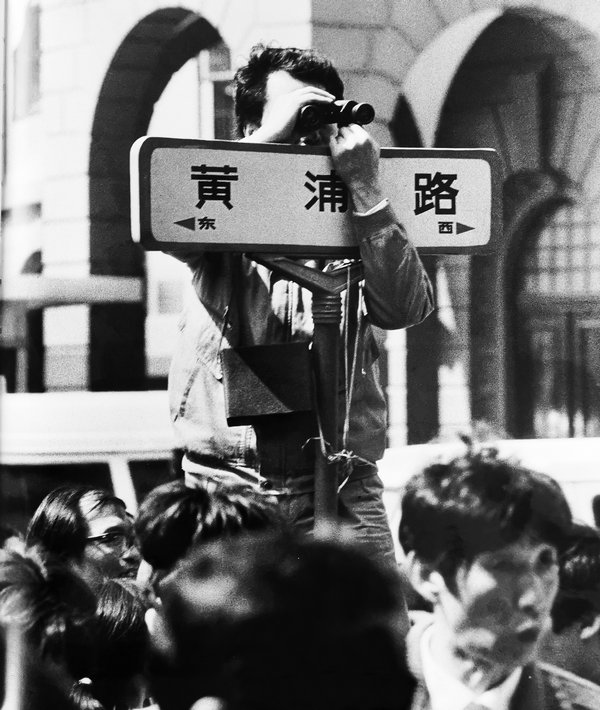 5.1992年邓小平南方谈话后，股市升温，全国炒股。图为在上海黄浦路上，股民用望远镜看爱建黄浦路营业部内股票行情。这也是在前网络时代，股票市场常见的景象.jpg